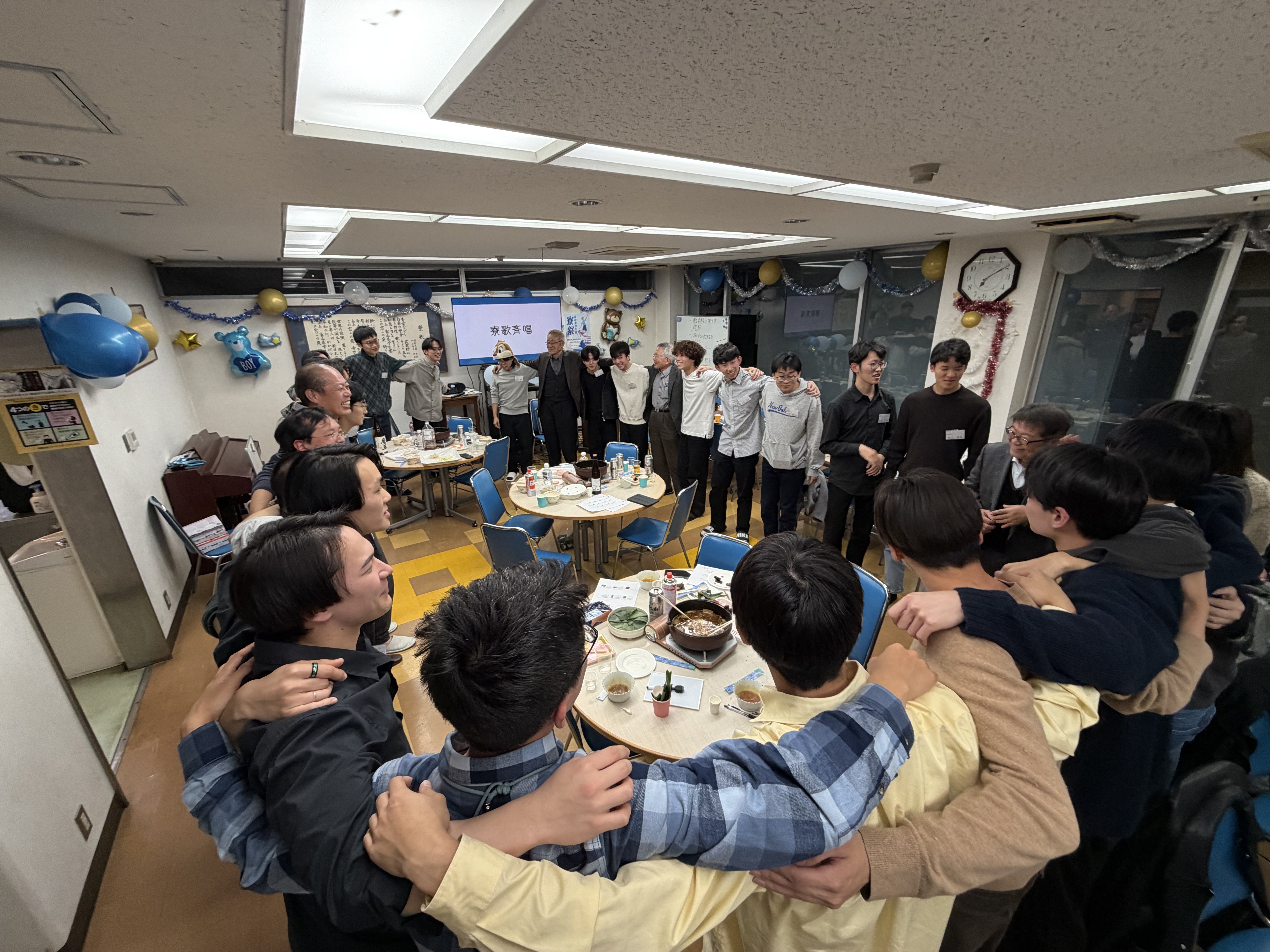 OBと寮生で円陣を組んで寮歌を合唱する様子