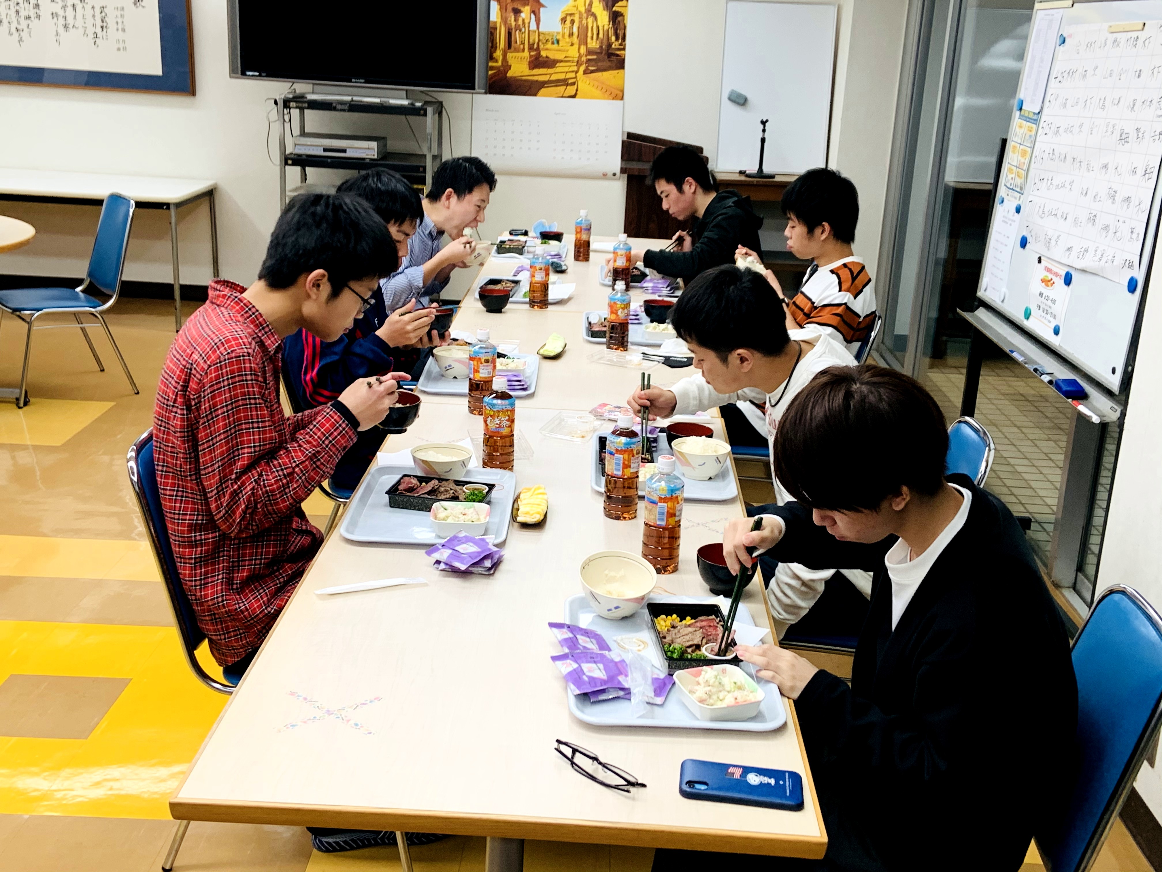 弁当を手に笑顔を見せる寮生