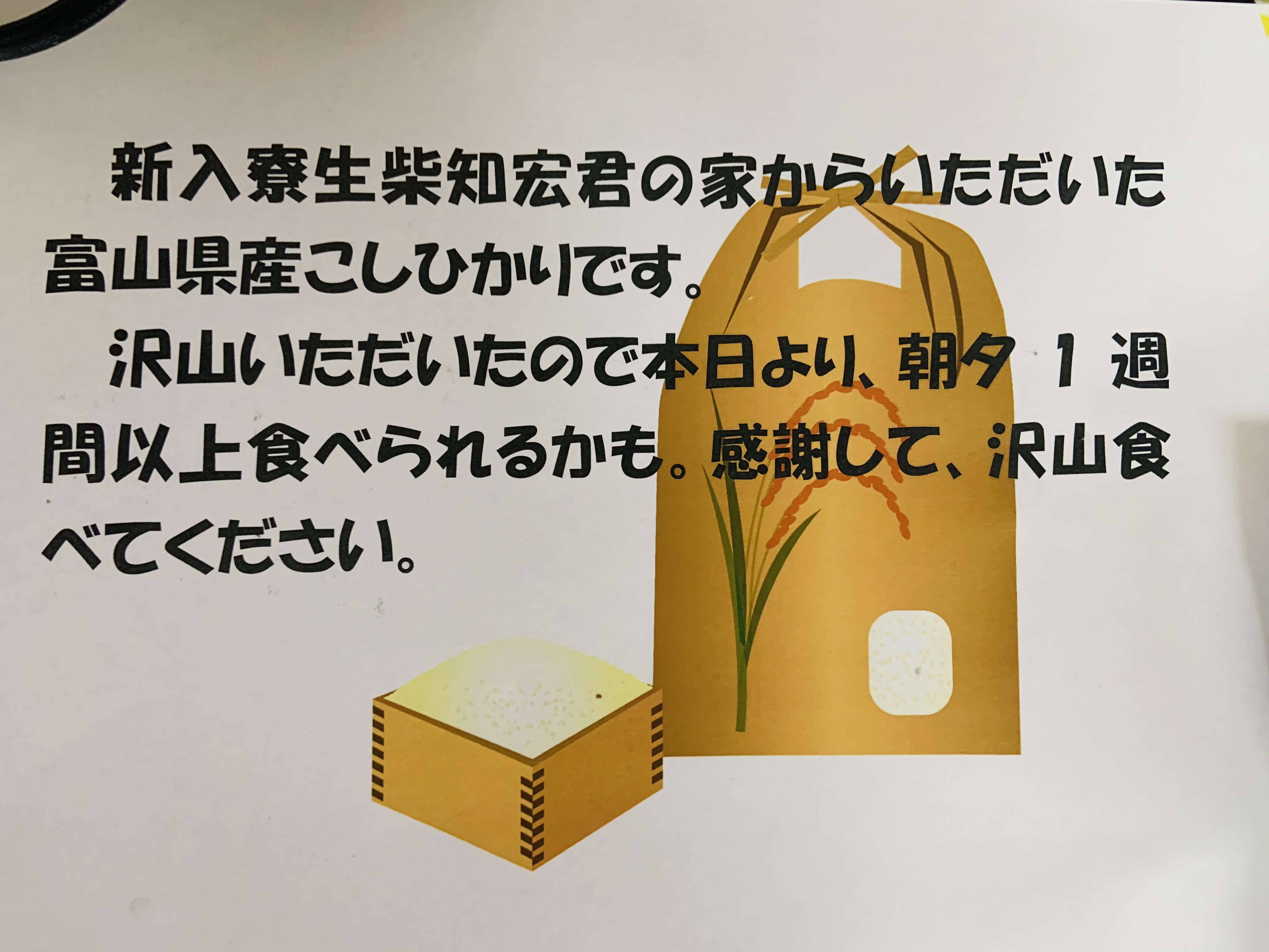 贈られたお米と笑顔の寮生