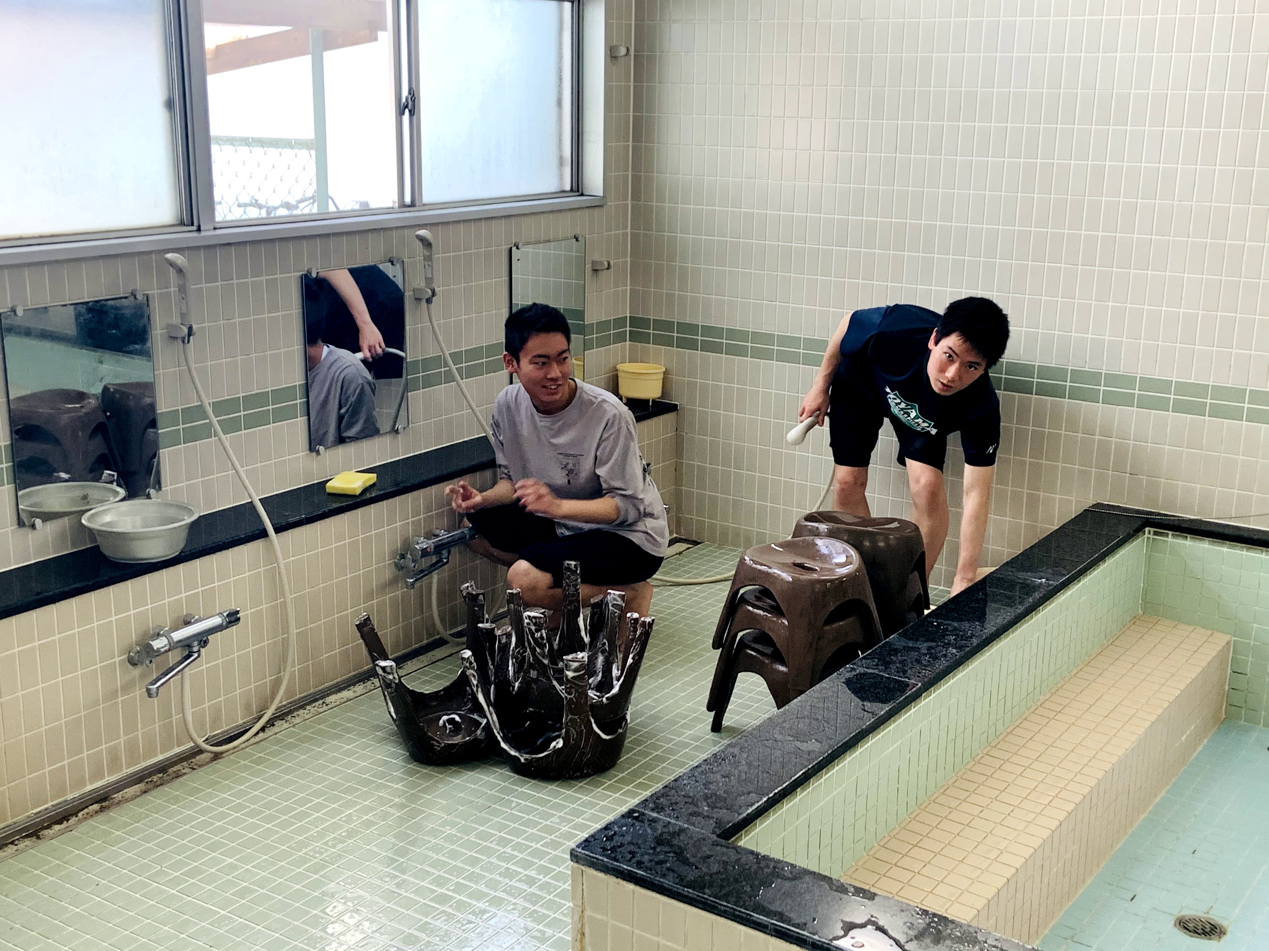 床をブラシでこする寮生