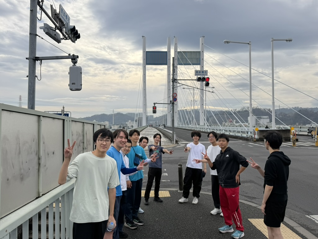 ゴール地点の是政橋で集合写真を撮る寮生たち