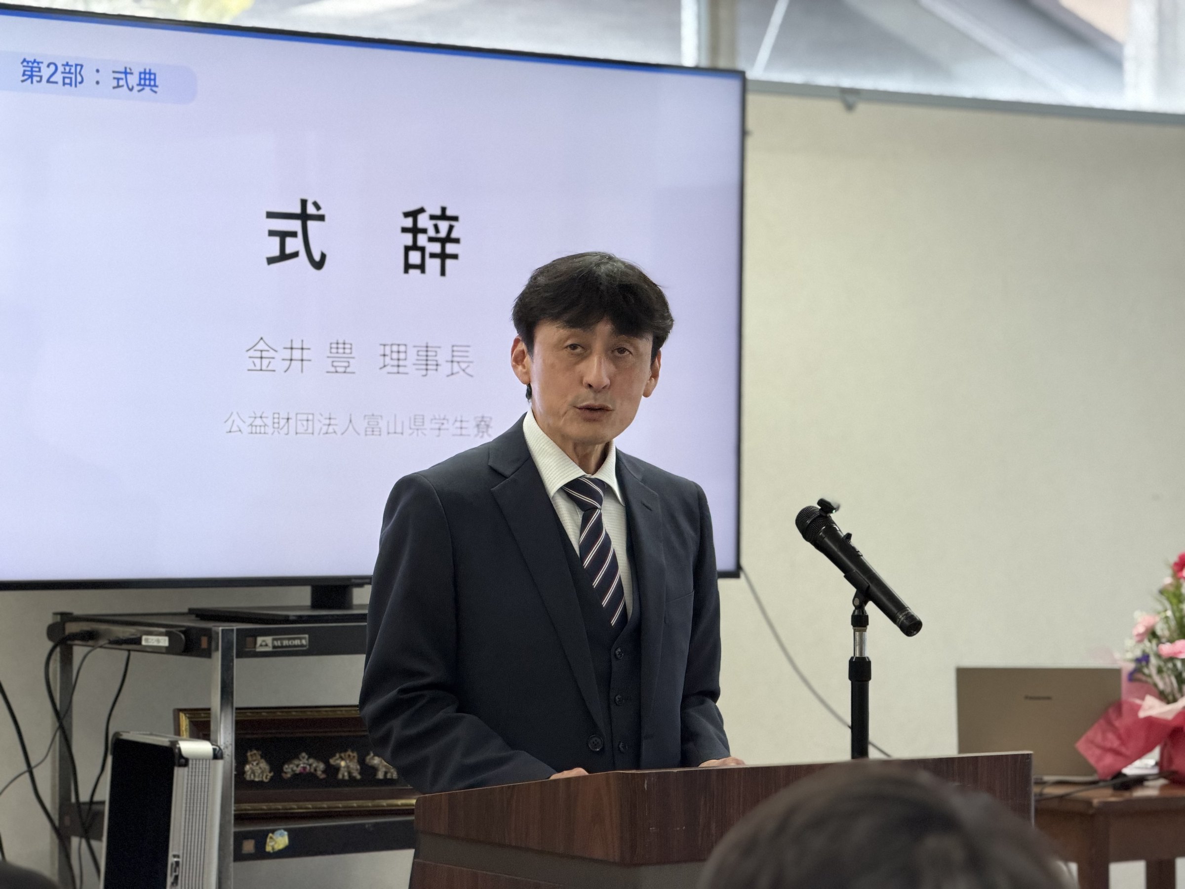 髙井郁大様が金井豊理事長様の式辞を代読される様子