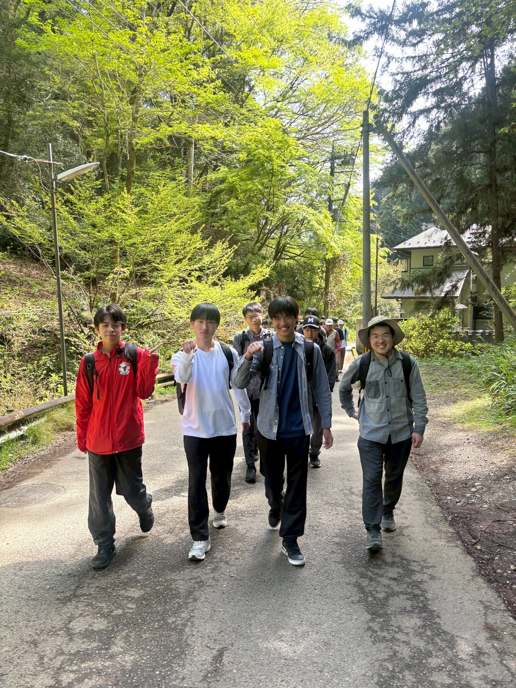 班ごとに声を掛け合いながら高尾山の登山道を歩く様子