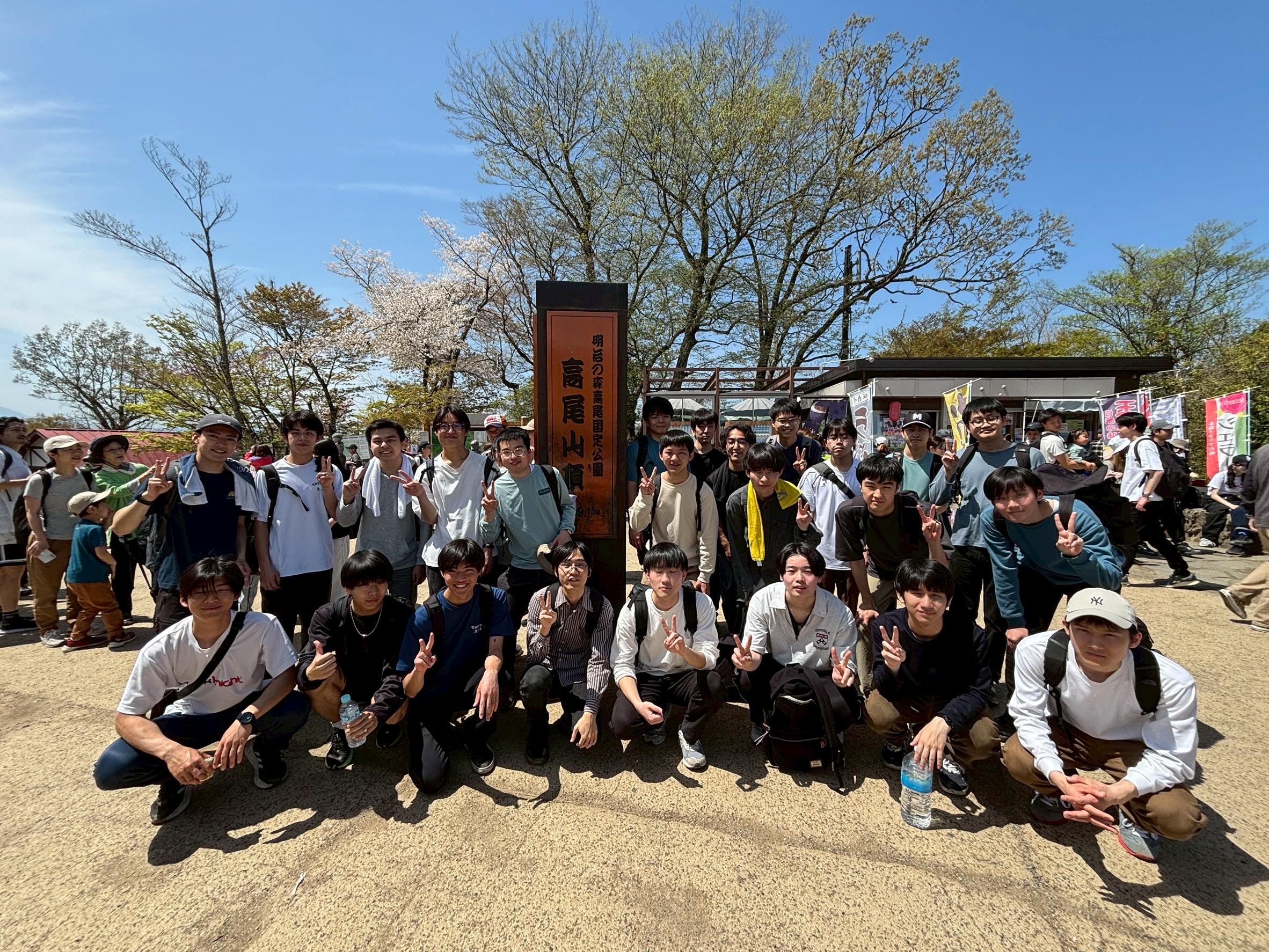 高尾山山頂で集合して記念写真を撮影する様子