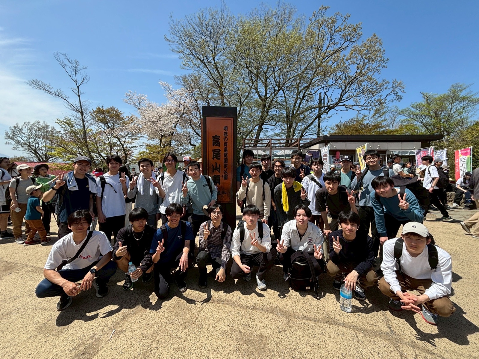 高尾山山頂で集合して記念写真を撮影する様子